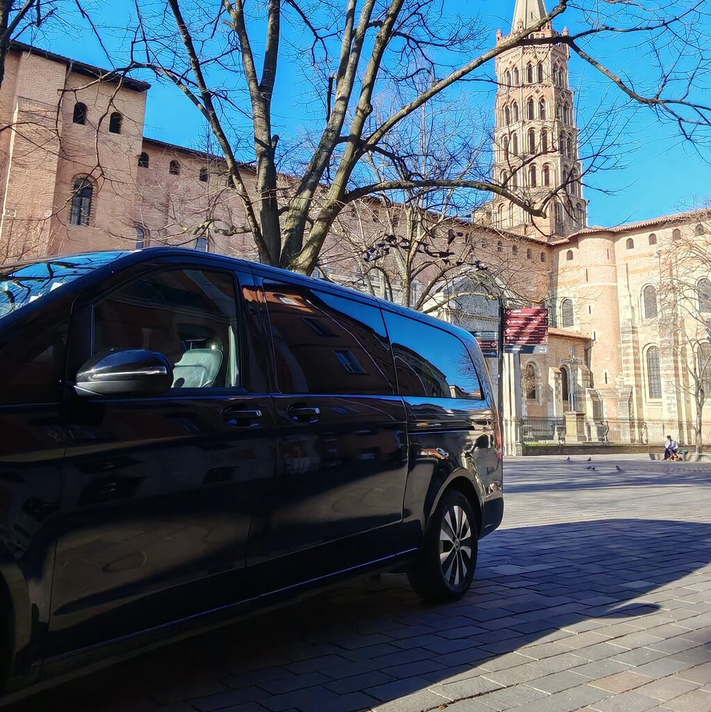 Van Mercedes Classe V noir Urban Prestige en dépose devant la basilique Saint-Sernin à Toulouse en hiver — accès marché de Noël