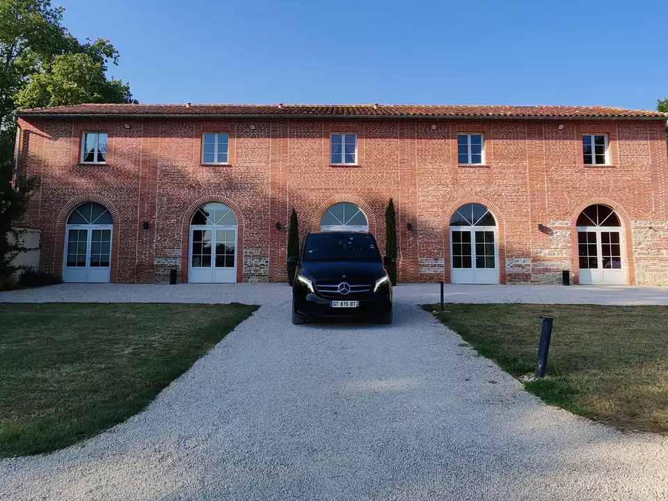 Van Mercedes Classe V avec chauffeur devant un domaine de mariage en brique toulousaine - Urban Prestige VTC
